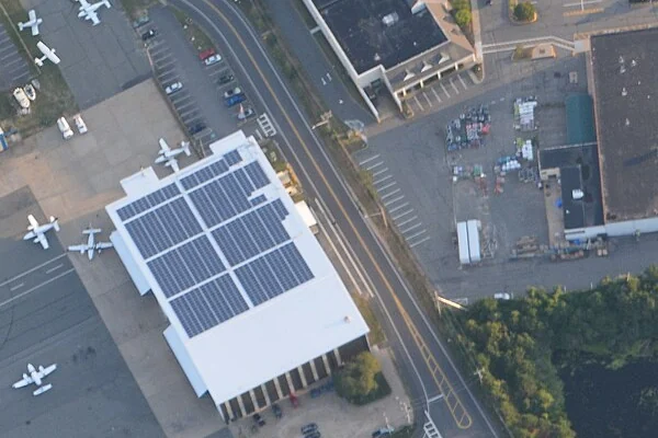 Aerial view of a solar panel array installed on a commercial building rooftop